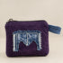 Angled view of purple purse with geometric denim decoration