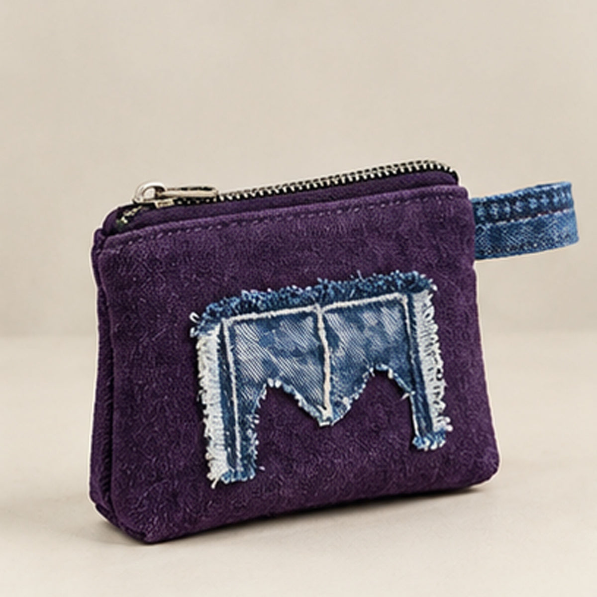 Front view of purple zip purse with frayed blue denim appliqué