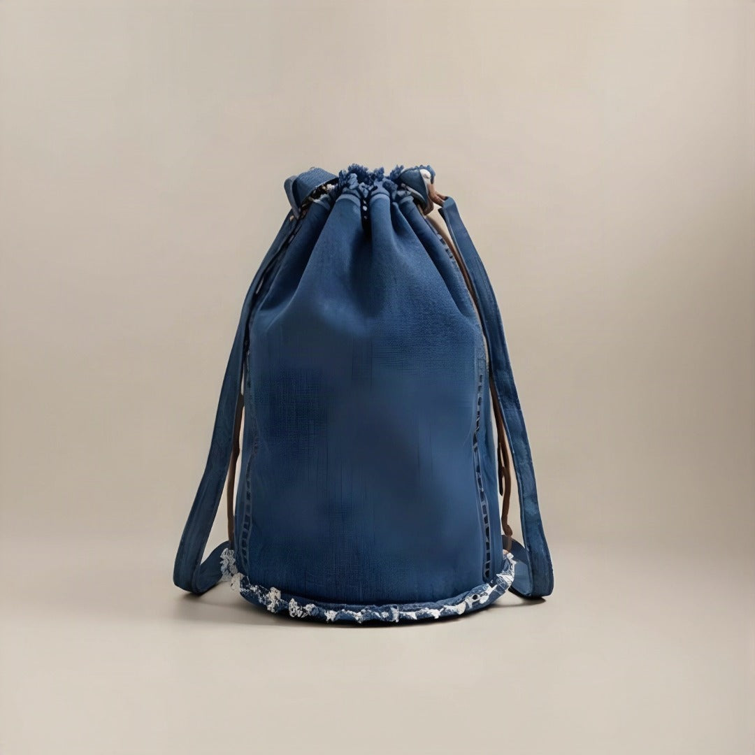 Close-up of raw frayed denim edges and brown leather drawstring detail