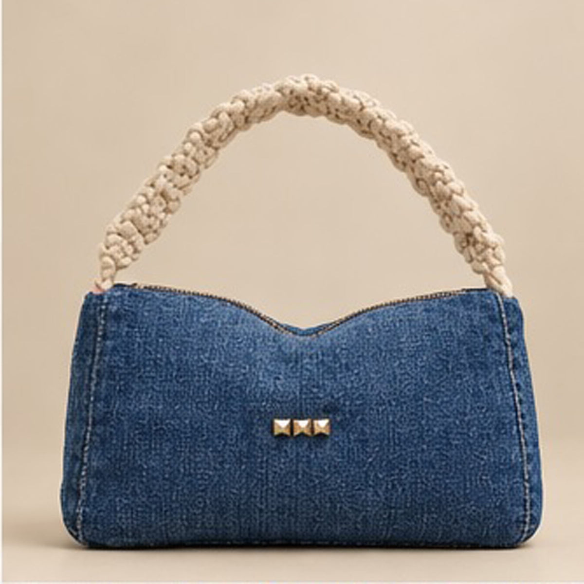 Front of blue denim baguette bag with cream braided handle and studded Nerakcos label