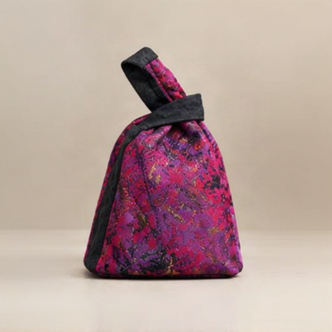 Lifestyle - model holding Nerakcos Floral Knot Bag on sofa