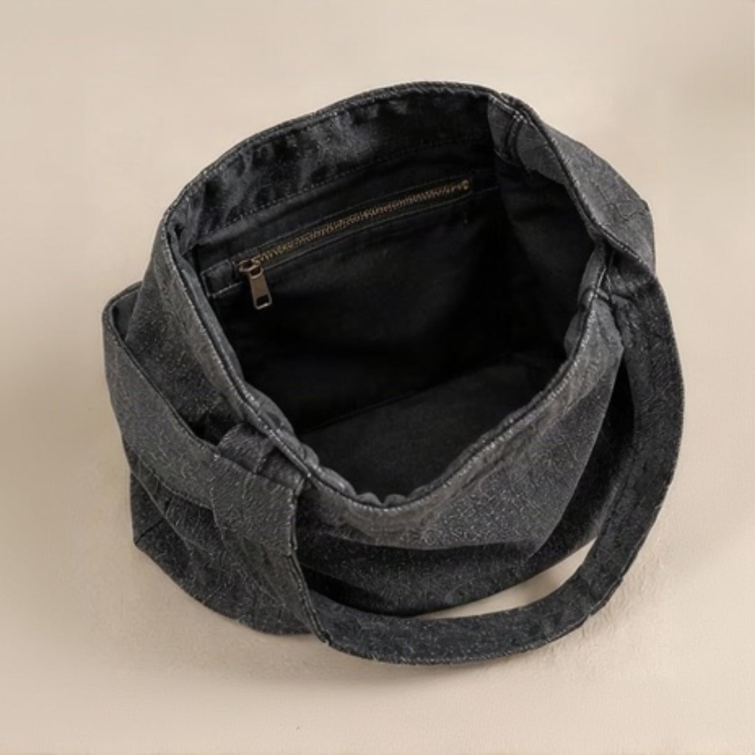 Model carrying Nerakcos Black Denim Bucket Bag