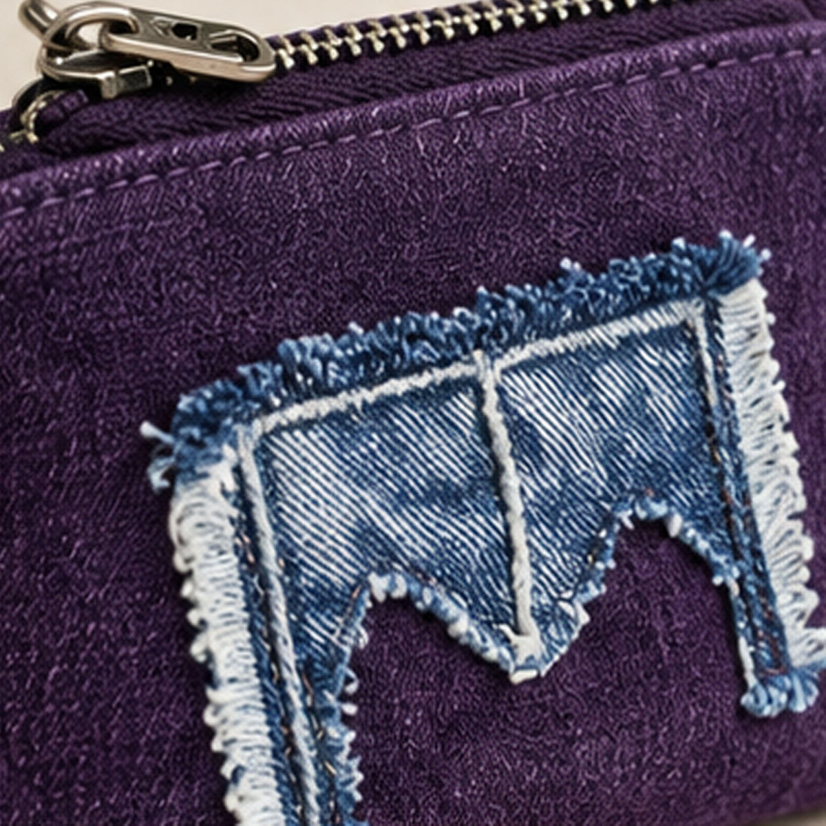 Three-quarter view of purple purse and denim side loop