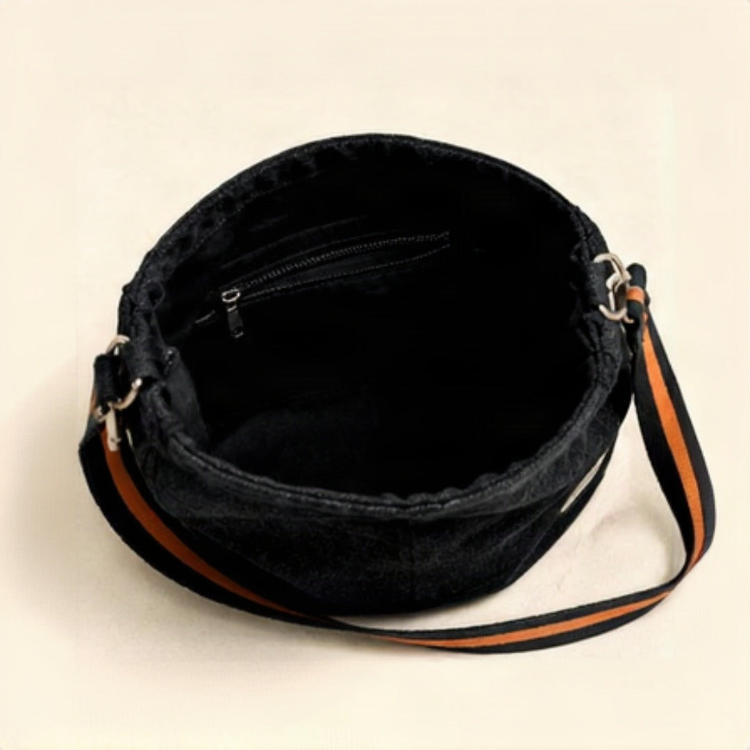 Close-up of silver D-ring hardware and orange striped sport strap detail