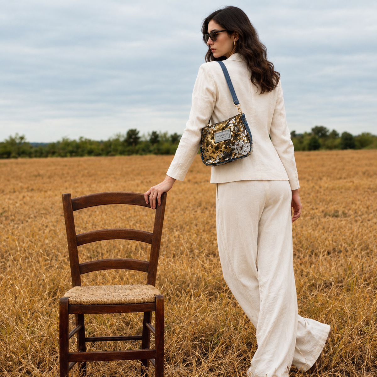Lifestyle - model wearing Nerakcos Gold Sequin Crossbody Bag crossbody, editorial outdoor setting