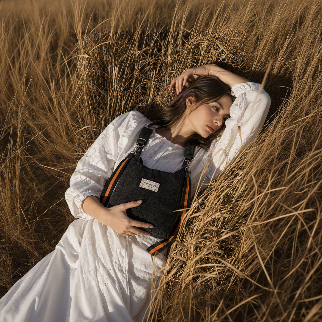 Nerakcos Black Denim Sport Bucket Bag - editorial lifestyle shot, model in golden wheat field